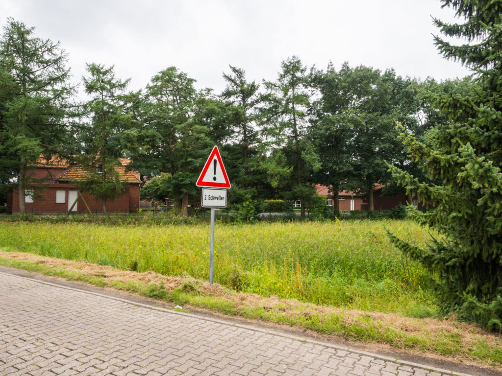 Grundstück mit Blick auf Grundschule und Straßenschild im Vordergrund